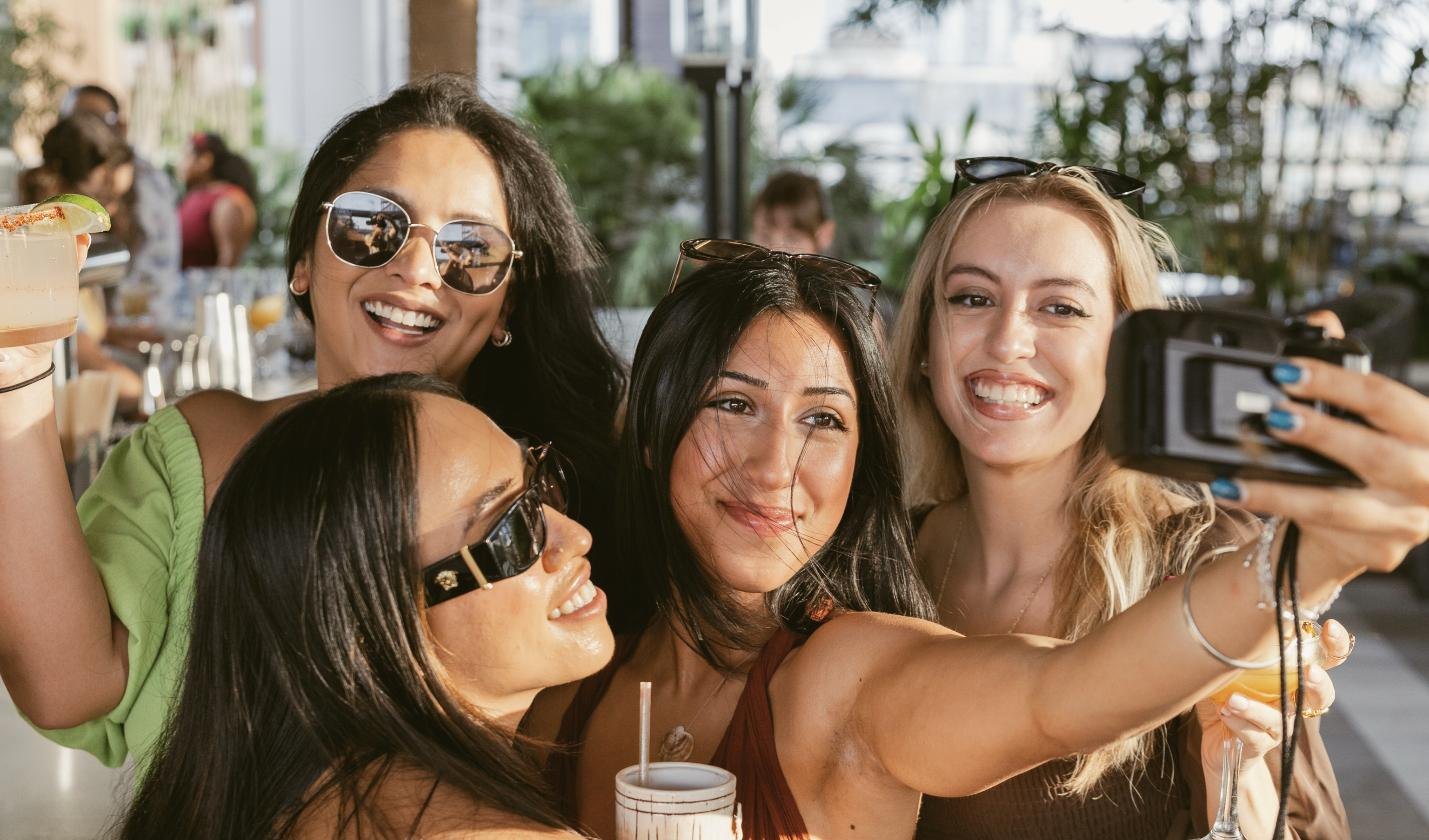 Friends taking a selfie on a rooftop bar in Austin